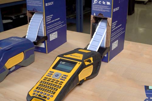 Une grande boîte d’étiquettes distribuées en continu à une étiqueteuse M610.