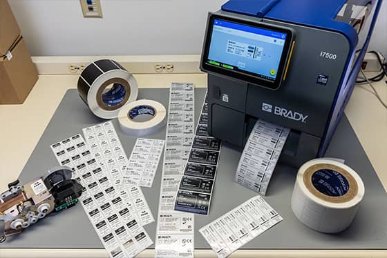 Un employé applique une étiquette de suivi de bien sur un ordinateur portable.