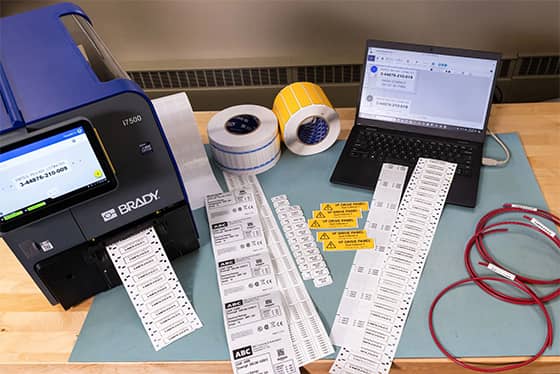 Un employé applique une étiquette de suivi de bien sur un ordinateur portable.