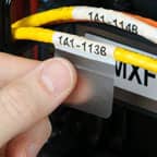 Un technicien applique une étiquette Brady auto-protégée sur un câble de données pour identifier sa fonction.