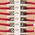 De nombreuses étiquettes Brady appliquées sur un bornier pour identifier chaque borne numérotée.