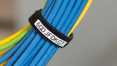 Étiquettes à crochets BradyGrip enroulées, sécurisant et identifiant un groupe de câbles de données.