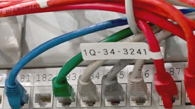 Une étiquette drapeau Brady de type P en polypropylène mat appliquée sur un câble Ethernet Cat-5e.