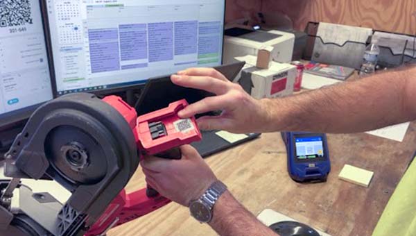 Une personne montre une étiquette sur un outil.